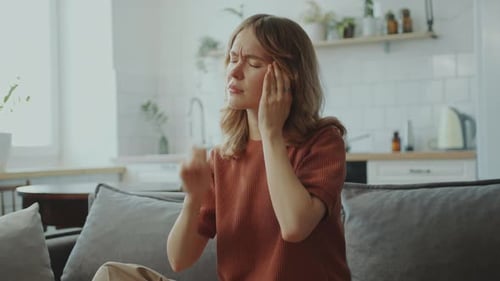Young Sick Woman Rubbing Temples as Suffering from Headache at Home