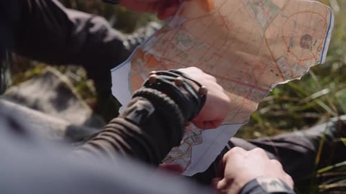 Hands of Couple of Tourists Hold a Piece of Paper Map and Check the Route