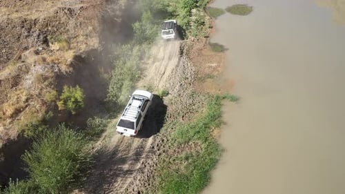 Aerial View Of Offroad Vehicles Driving In Green Area By Creek