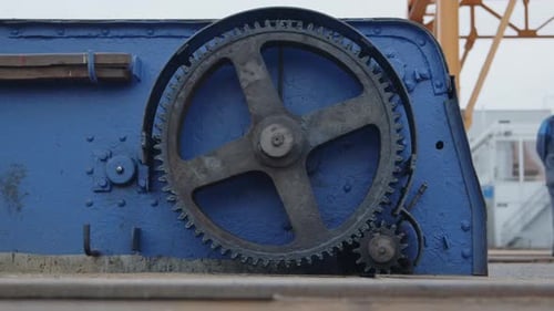 a large and small gear wheels spinning on a construction site, static close up