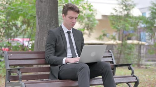 Young Adult Man Working on Laptop in Park
