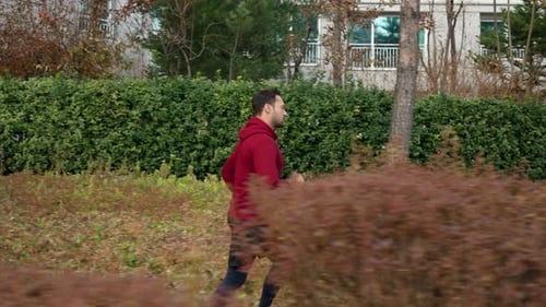 Middle Age Man Running in Autumn Park - side view slow motion