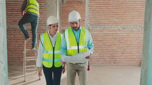 Engineers Inspecting Construction Site with Blueprints