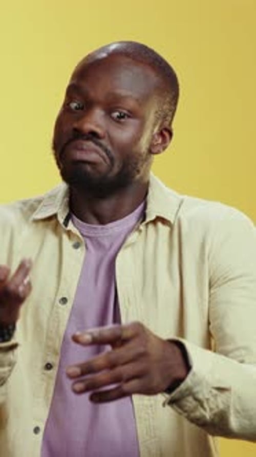 Bearded man standing in front of yellow background