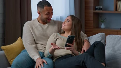 Couple Relaxing Together on the Sofa With Phone