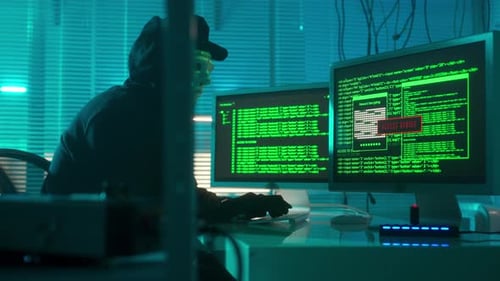 Hacker in a White Mask is Typing on a Computer Keyboard and Cracking a Password