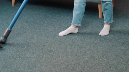 Close up of vacuum cleaner vacuuming carpet in modern apartment