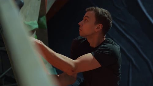 Man Climbing Indoor Rock Wall for Exercise
