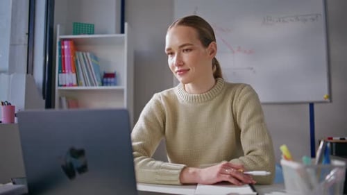 Woman Working with Laptop in a Classroom Setting