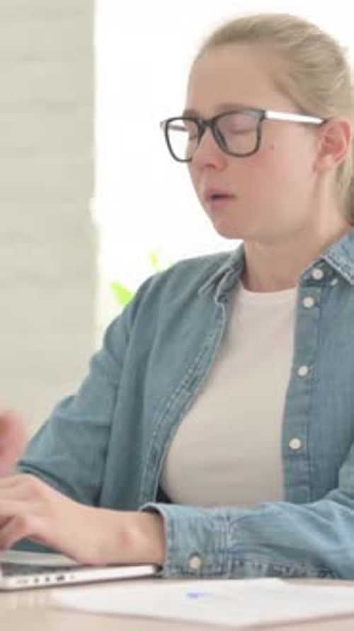 Young Woman Coughing While Working on Laptop at Home