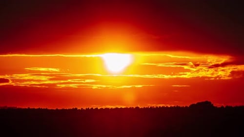 Dramatic Sunset with Sun Rays in the Sky Through Orange Layered Clouds Timelapse