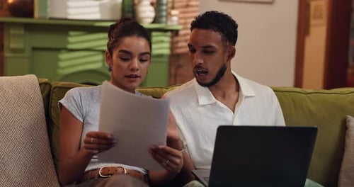 Young Couple Using Laptop and Paper Documents
