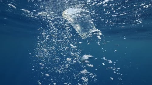 Plastic Cup Drifting Underwater in Ocean with Bubbles