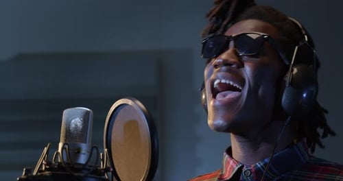 Energetic Black Male Singer Recording a New Song in Professional Studio. Expressive Youn