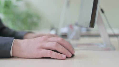 Side View of Businessman Using Mouse and Typing on Desktop Keyboard