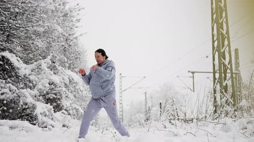 Man Shadow Boxing in Snowy Winter Landscape