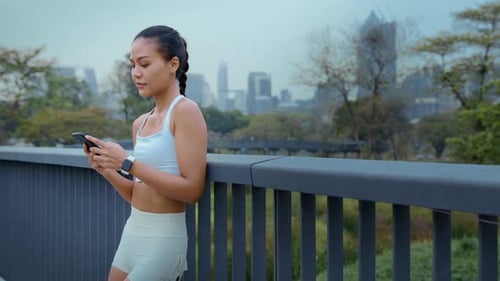 Woman Using Phone After Outdoor Workout in City