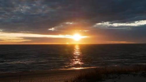Timelapse of sunset in Baltic sea with cloudy and stormy sky. Beautiful red sunset.