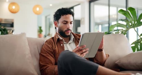 Typing, relax and tablet with man on sofa for social media post, reading and online update
