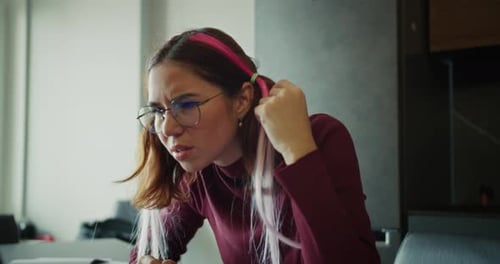 Woman With Headache Rubbing Temples at Computer