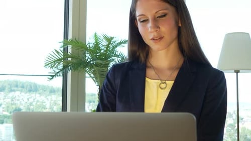 Young Woman Working on Laptop in Office