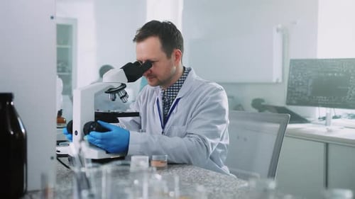 Scientist Using Microscope in Bright Medical Laboratory