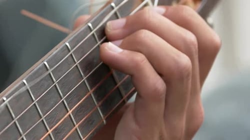 Young hands playing chords and a small solo on a vintage classic guitar with nylon chords