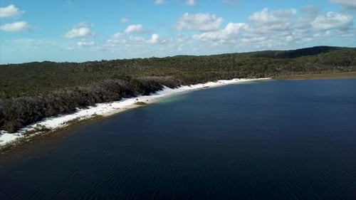 drone shot Lake Mckenzie on Fraser Island Australia descending towards white sand beach