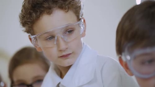 Children in Lab Coats Studying Science in Classroom