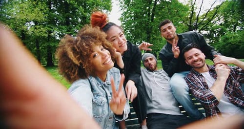 Zeitlupe einer Gruppe junger Freunde verschiedener Ethnien, die Spaß haben und ein Selfie machen