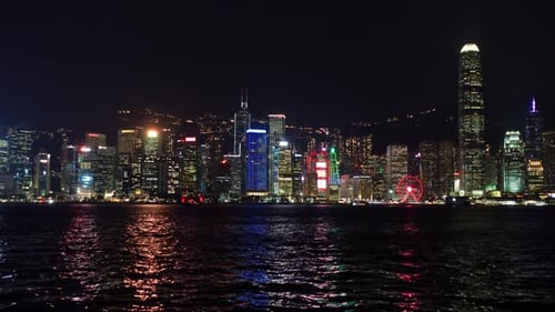 Nighttime Aerial View of Hong Kong Skyline with Illuminated Skyscrapers and Harbour Reflections