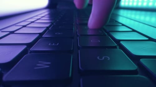 Primer plano de las manos escribiendo y codificando en el teclado del ordenador portátil