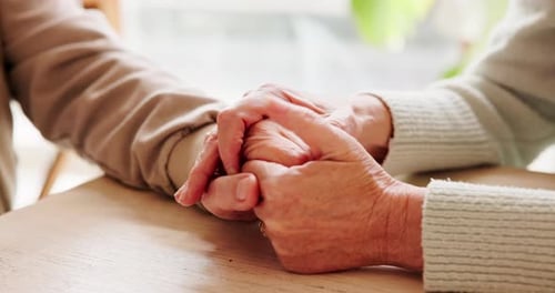 Holding hands, connection and senior couple by table for love, empathy or forgiveness in marriage