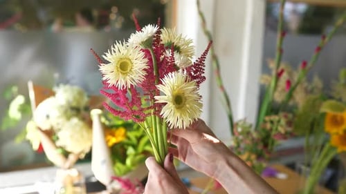 Woman Arranging White and Red Flowers in Florist Shop
