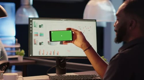 Office Worker Holding Smartphone with Horizontal Greenscreen