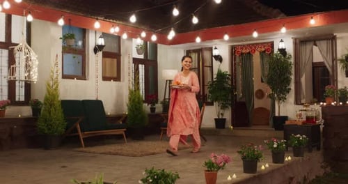 Woman Bringing Food to Outdoor Evening Celebration