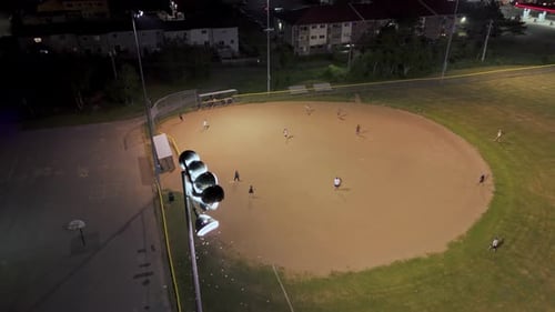 Aerial View of a Baseball Field at Night with Players Playing American Baseball