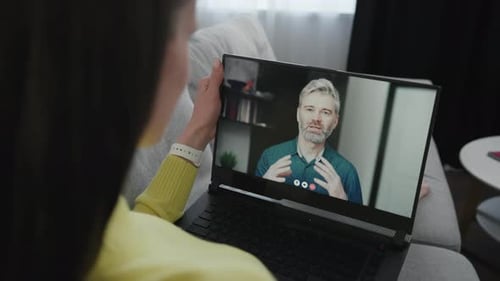 Young Girl Student Greeting Her Coach By Waving Hand Via Webcam in Laptop