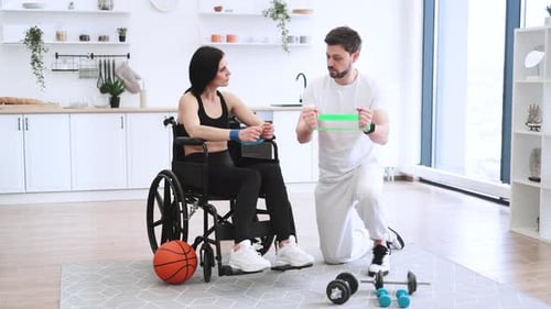 Woman in Wheelchair Exercises With Therapist