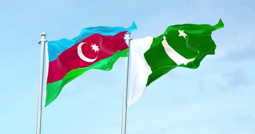 Azerbaijan and Pakistan Flags Waving Against Blue Sky