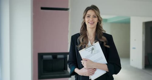 Blonde Real Estate Agent Delicately Holds Contract Plan Gracefully Extends the Keys Towards the