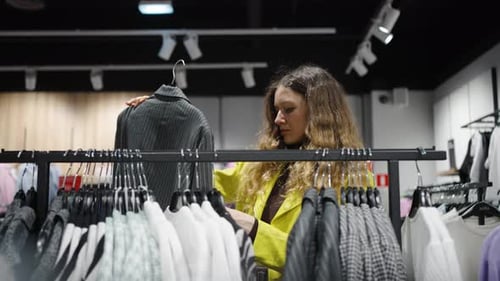 Young Woman Shopping for Clothes in Modern Fashion Store