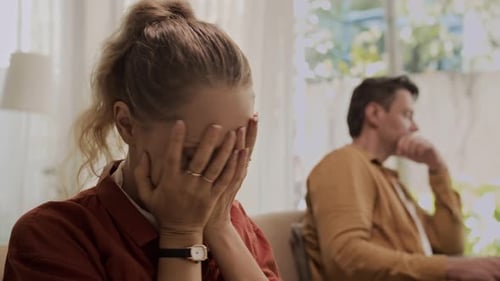 Distressed Woman with Man on Couch Indoors