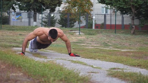 Muscular Man Doing Push-Ups Outside