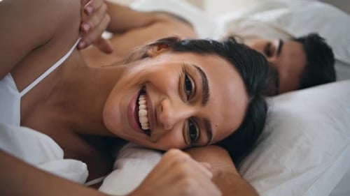 Happy Woman Smiling in Bed with Partner