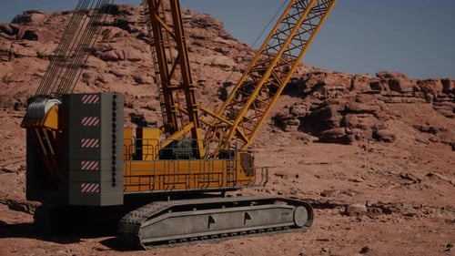 Une grande grue jaune assise au sommet d'une colline rocheuse