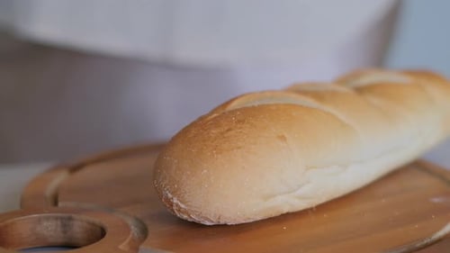 Slicing Fresh Bread on Wooden Board Close Up