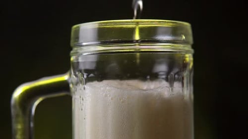 Pouring Beer into a Clear Glass Mug