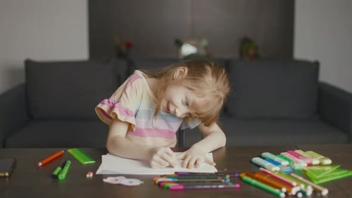 Girl Drawing on Paper at Home with Crayon