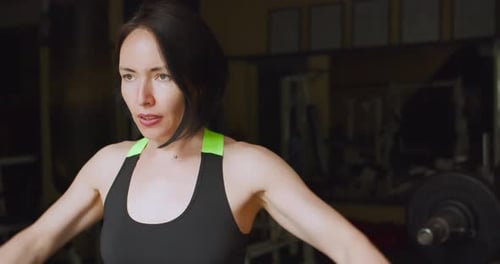 Fit Caucasian Woman During Gym Workout Deltoid Workout with Dumbbells